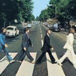 The Beatles walking across the Abbey Road crosswalk in London.